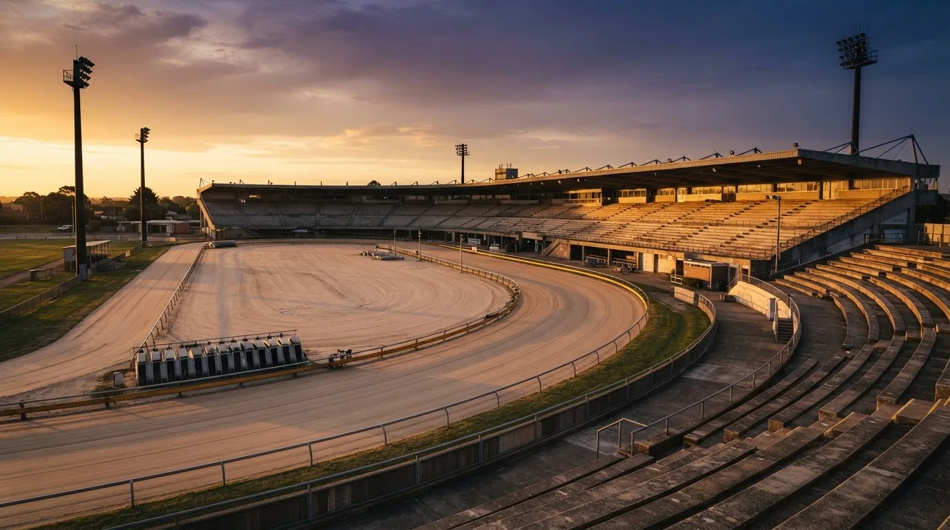 Un estadio de fútbol vacío con torres de iluminación al atardecer