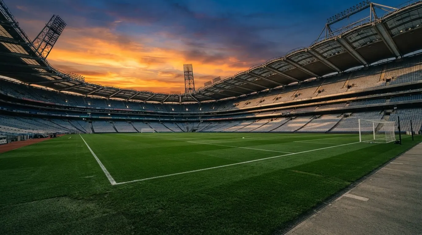 Un estadio de fútbol vacío con torres de iluminación al atardecer